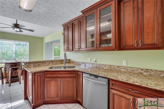 kitchen with dishwasher, sink, ceiling fan, light tile patterned floors, and a textured ceiling