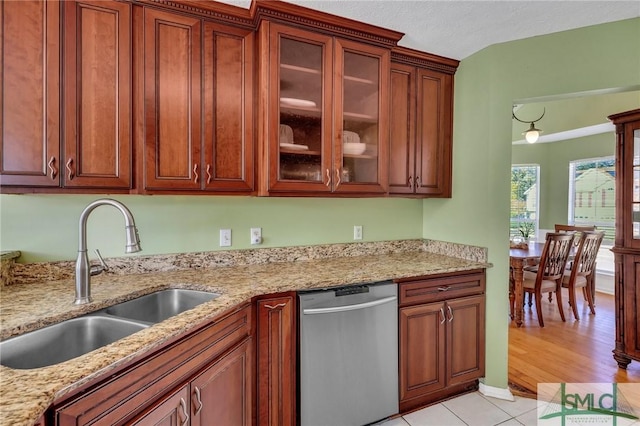 kitchen featuring light stone countertops, sink, stainless steel dishwasher, and light hardwood / wood-style flooring