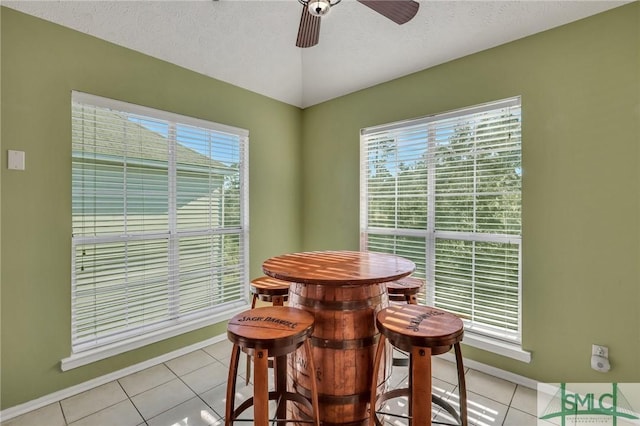 tiled dining area featuring ceiling fan and a textured ceiling