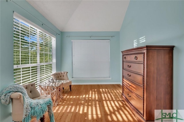 sitting room featuring lofted ceiling and light wood-type flooring