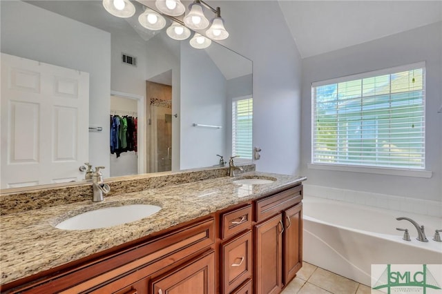 bathroom with tile patterned flooring, vanity, separate shower and tub, and vaulted ceiling