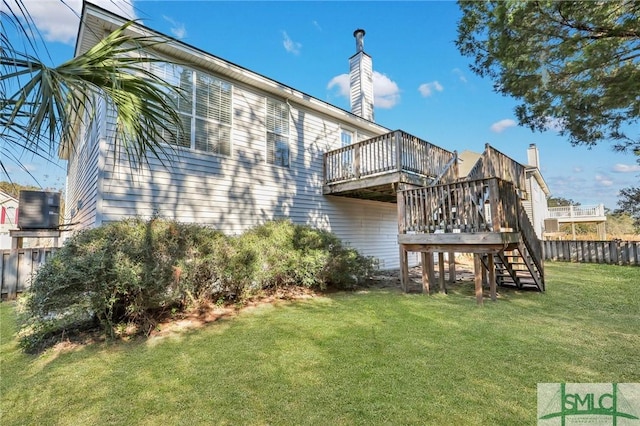 rear view of house featuring a deck and a yard