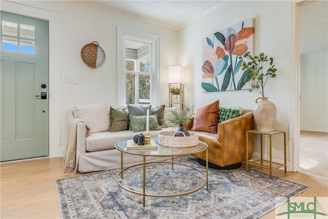 sitting room featuring wood-type flooring, a wealth of natural light, and ornamental molding