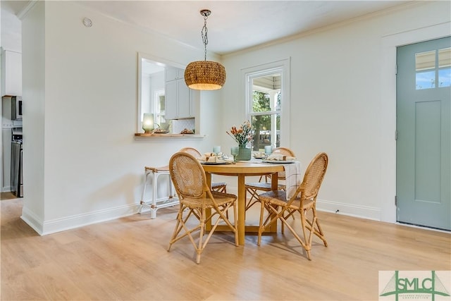 dining space with light wood-type flooring and crown molding