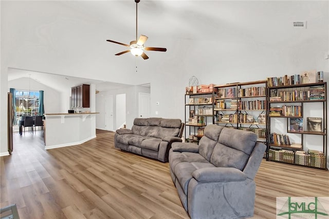 living room with light hardwood / wood-style floors, ceiling fan, and lofted ceiling