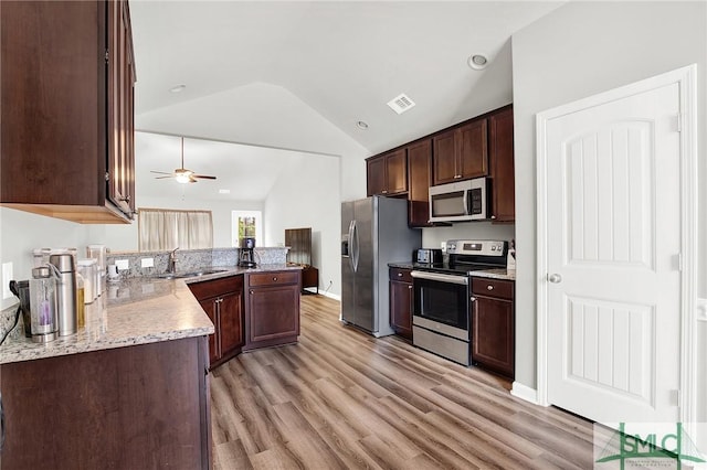 kitchen featuring lofted ceiling, sink, ceiling fan, light hardwood / wood-style floors, and stainless steel appliances