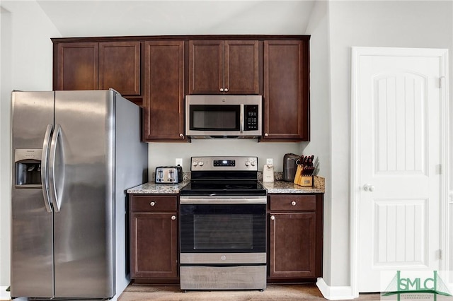 kitchen with dark brown cabinetry, light stone countertops, and appliances with stainless steel finishes