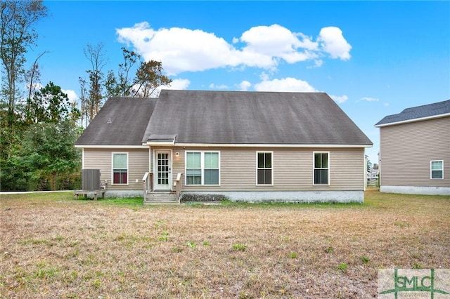 back of house featuring central AC unit and a yard