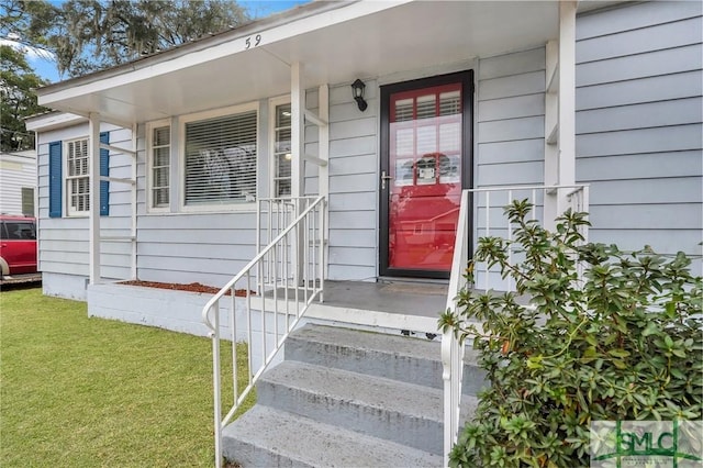 entrance to property with a lawn