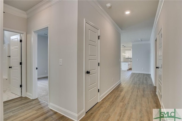 hall with crown molding and light hardwood / wood-style flooring