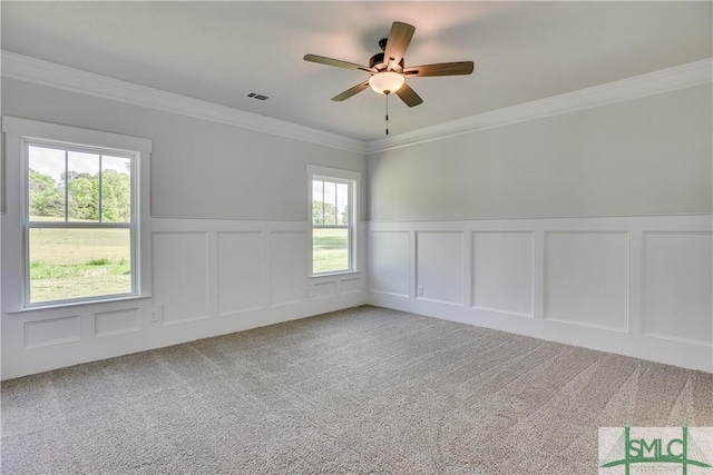 spare room with carpet flooring, a wealth of natural light, and ornamental molding