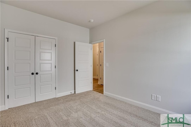 unfurnished bedroom featuring a closet and light colored carpet