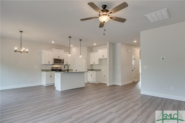 unfurnished living room with ceiling fan with notable chandelier and light wood-type flooring