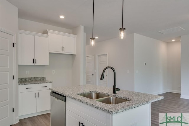 kitchen with stainless steel dishwasher, white cabinets, sink, and a kitchen island with sink