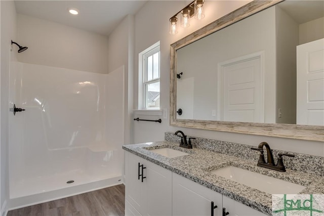 bathroom featuring vanity, a shower, and wood-type flooring