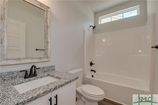 full bathroom with toilet, vanity, wood-type flooring, and washtub / shower combination