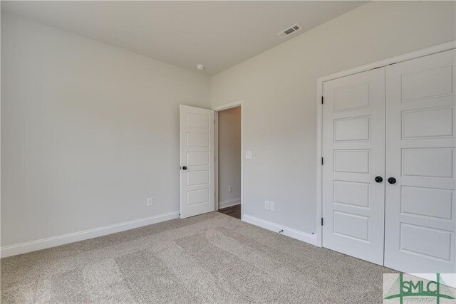 unfurnished bedroom featuring carpet flooring and a closet