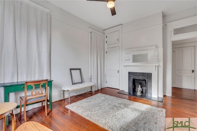 living room featuring ceiling fan and dark wood-type flooring