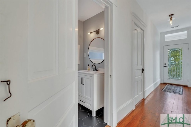 foyer entrance with sink and dark wood-type flooring