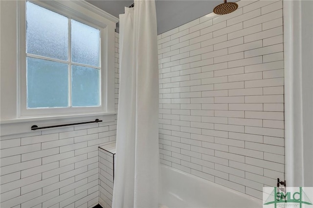 bathroom with a wealth of natural light and shower / tub combo with curtain