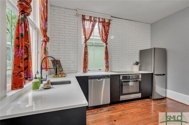 kitchen with sink, appliances with stainless steel finishes, and light hardwood / wood-style flooring