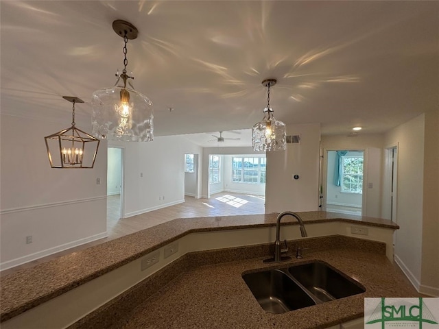 kitchen with ceiling fan, sink, and decorative light fixtures