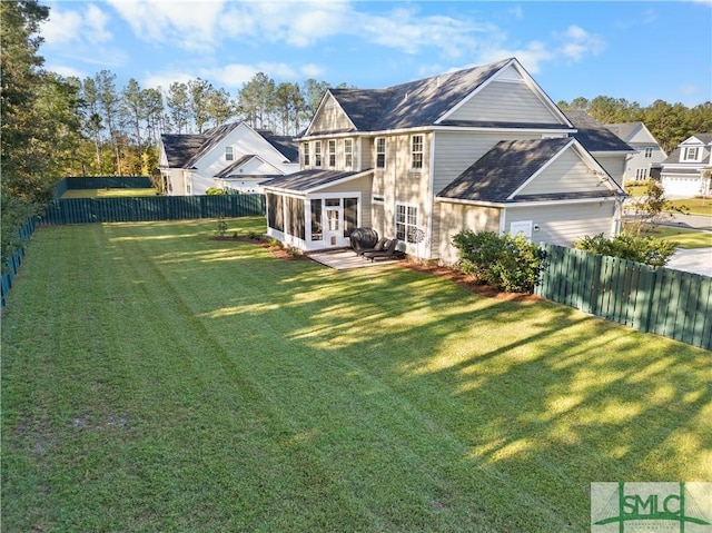 rear view of house with a lawn and a sunroom