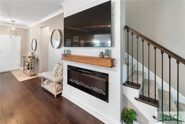 living room featuring crown molding, a chandelier, and dark hardwood / wood-style floors