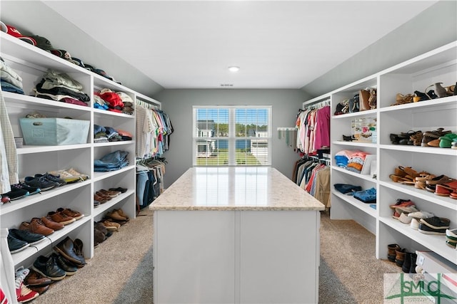 spacious closet featuring light colored carpet and vaulted ceiling