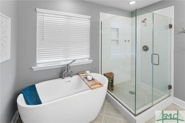 bathroom with tile patterned flooring and separate shower and tub