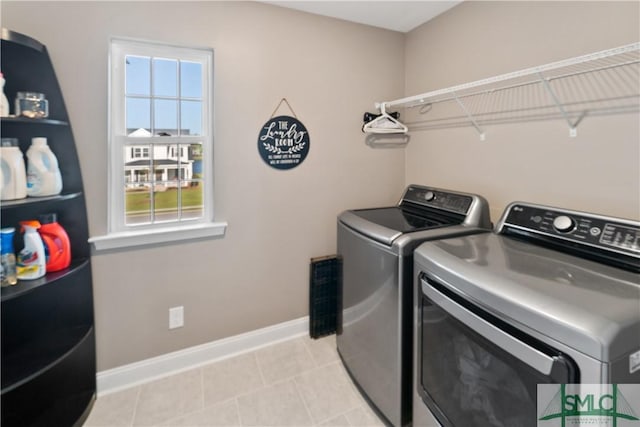 clothes washing area featuring washing machine and dryer and light tile patterned floors