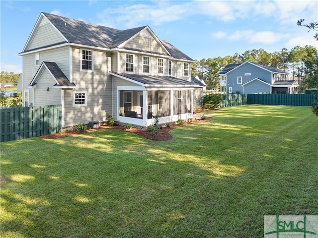 back of property featuring a sunroom and a yard