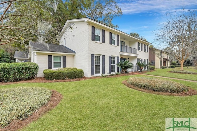 view of front of property with a balcony and a front lawn