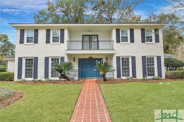 view of front of property with a balcony and a front yard