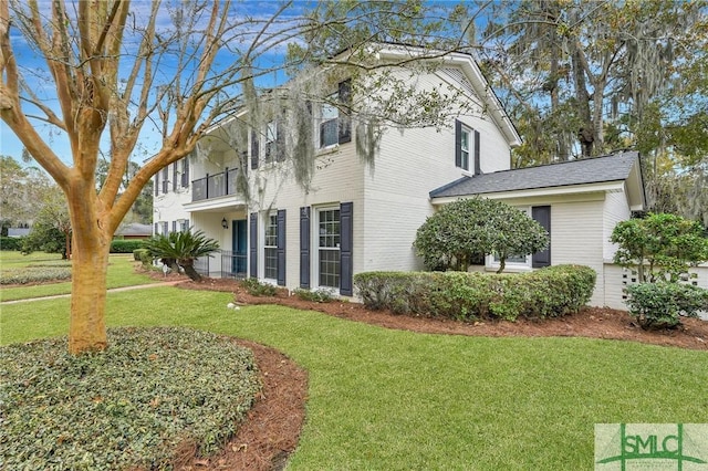 view of property exterior with a lawn and a balcony