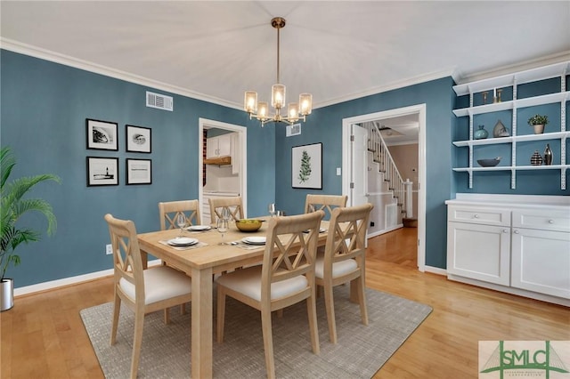 dining room featuring a chandelier, ornamental molding, and light wood-type flooring