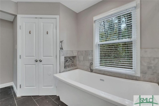 bathroom featuring a bath and tile walls