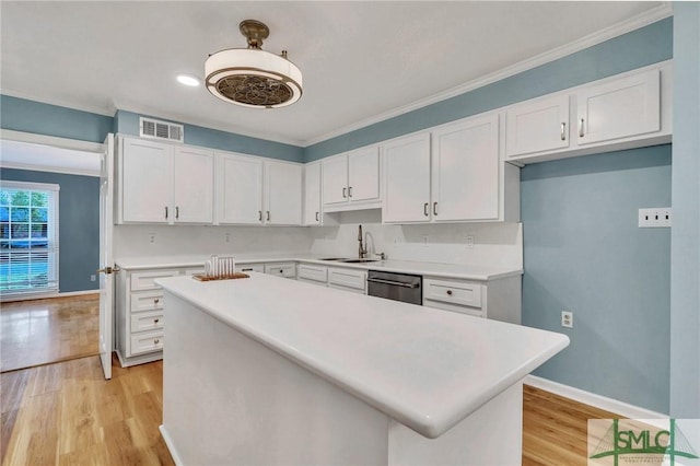 kitchen featuring white cabinets, light hardwood / wood-style floors, and stainless steel dishwasher