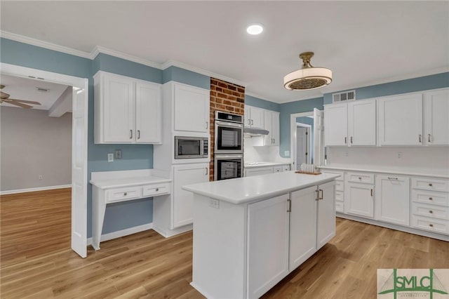 kitchen with a kitchen island, light wood-type flooring, white cabinetry, and appliances with stainless steel finishes