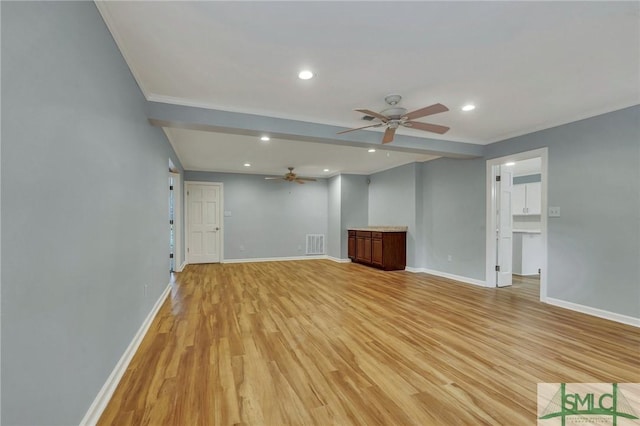 unfurnished living room featuring ceiling fan, ornamental molding, and light hardwood / wood-style flooring