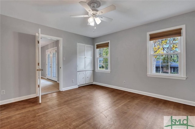 unfurnished bedroom featuring ceiling fan, dark hardwood / wood-style flooring, and multiple windows