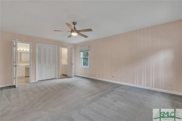 unfurnished bedroom with ensuite bathroom, ceiling fan, and light carpet