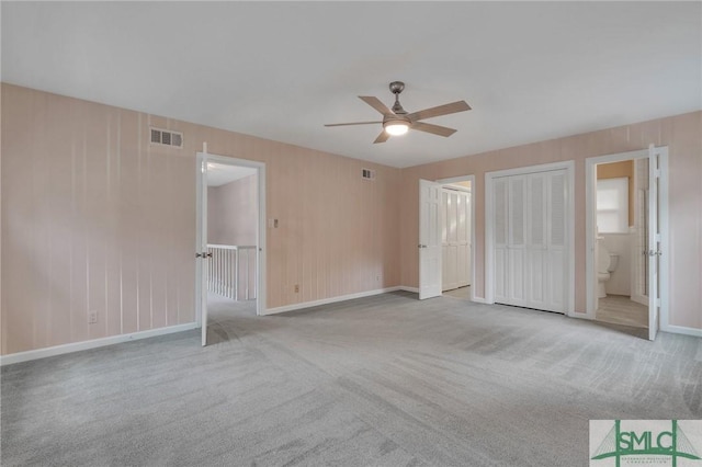 unfurnished bedroom featuring ensuite bathroom, ceiling fan, and light carpet