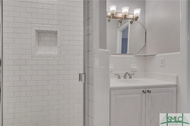 bathroom with vanity, walk in shower, and tile walls