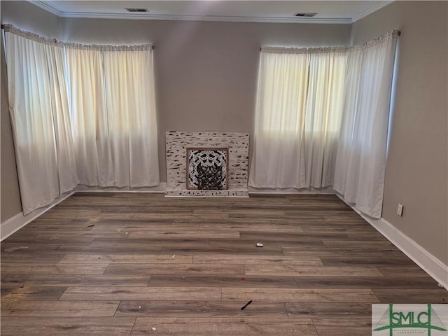 unfurnished living room featuring crown molding and dark wood-type flooring