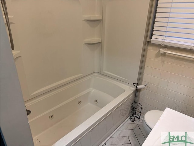 bathroom with toilet and tile walls