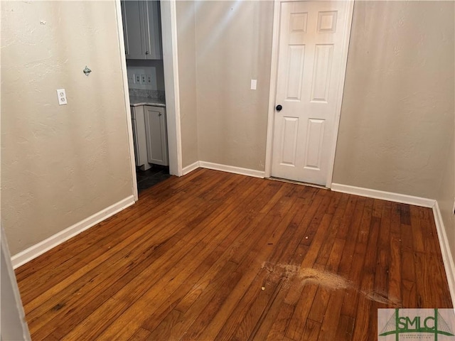 unfurnished room featuring dark wood-type flooring