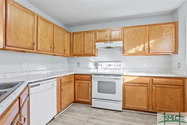 kitchen with a textured ceiling, light hardwood / wood-style flooring, and white appliances