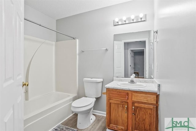 full bathroom featuring vanity, hardwood / wood-style flooring, toilet, a textured ceiling, and tub / shower combination