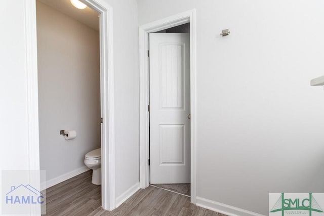 bathroom with hardwood / wood-style flooring and toilet